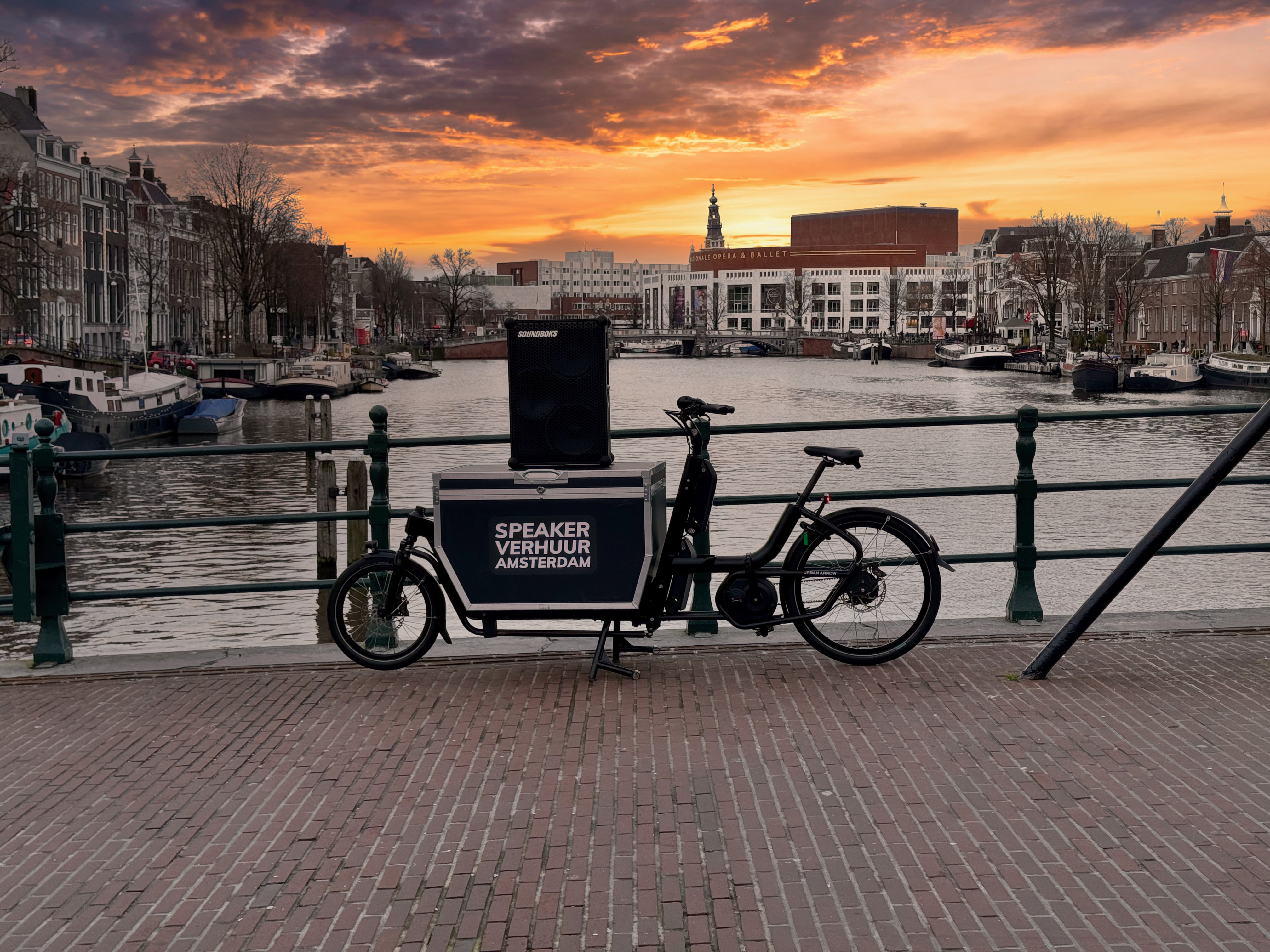 De bakfiets van Speaker Verhuur Amsterdam met Soundboks speaker aan de Amstel
